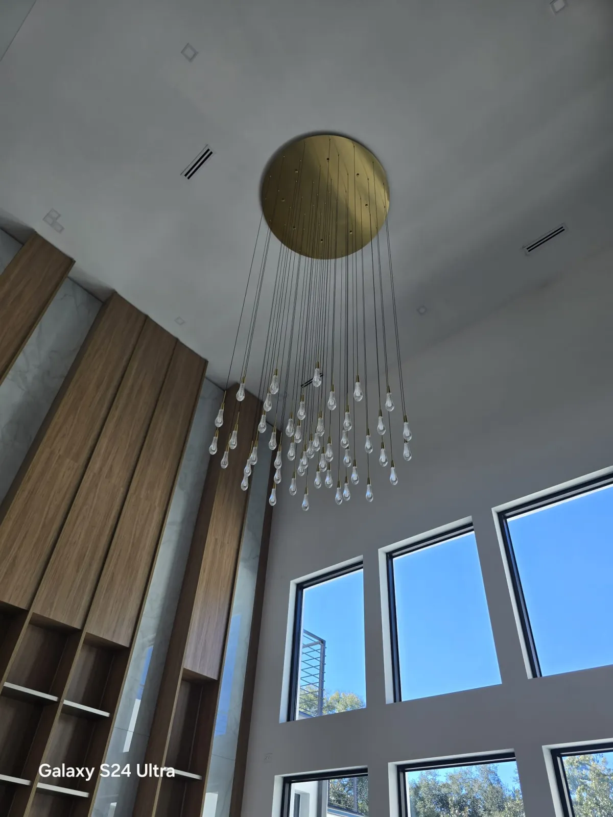 Large crystal drop chandelier installed on a double-height ceiling in Orlando, FL